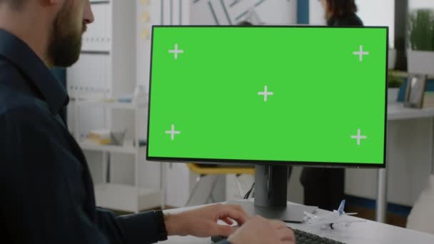 Nahaufnahme eines Mannes, der auf Tastatur tippt, mit grünem Bildschirm auf dem Monitor — Stockvideo