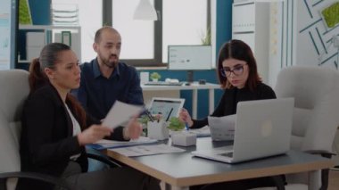 Bilgisayar kullanan meslektaşlar ve veri tablosu olan kağıtlar