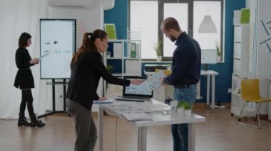 Kadın ve erkek şirket ofisinde iş stratejisi için takım çalışması yapıyor. Proje planlama ve geliştirme için veri tabloları ve dizüstü bilgisayarlarla çalışan meslektaşlar. İş arkadaşları beyin fırtınası yapıyor.