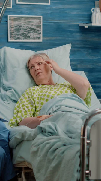 Medische assistent in bed in gesprek met oudere patiënt met ziekte — Stockfoto