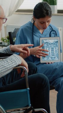 Hemşire tablet üzerinde osteopati x ışınını açıklıyor.