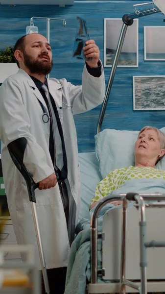 Old patient with disease receiving visit from doctor