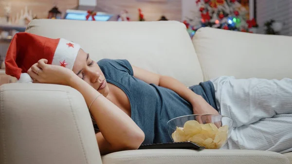 Primer plano de la mujer festiva durmiendo en el sofá en la televisión — Foto de Stock