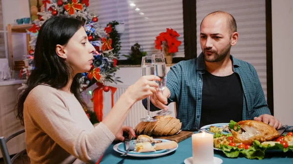 Uomo e donna che si accarezzano bicchieri di champagne a cena festiva — Foto Stock