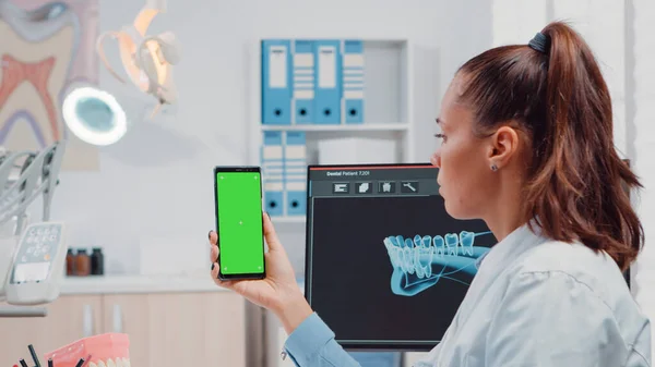 Primo piano dello smartphone ortodontista con schermo verde — Foto Stock