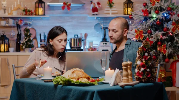Coppia guardando computer portatile e mangiare pasto festivo — Foto Stock