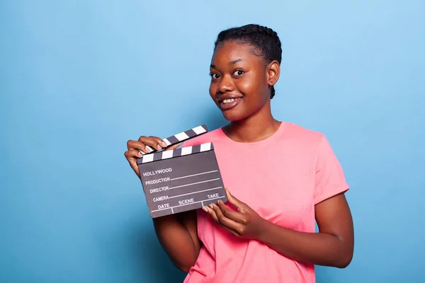 Ritratto di giovane donna afro-americana sorridente che tiene una lavagna per la produzione cinematografica — Foto Stock