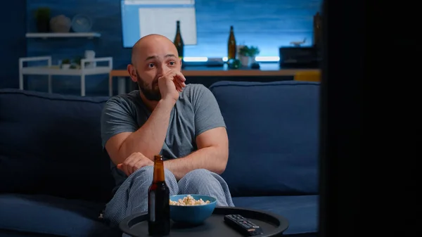 怖いです男見ホラー映画上のテレビ食べるポップコーン上のソファ — ストック写真