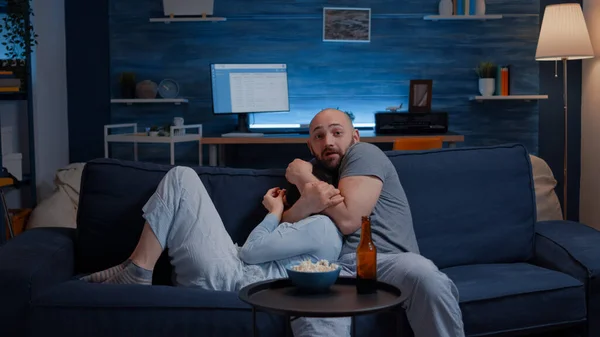 Chocado assustado jovem casal comer pipoca assistindo horror filme no tv — Fotografia de Stock