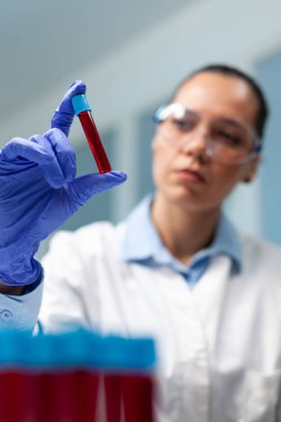 Kimyager doktor, tıbbî boşaltıcıyı kanla analiz ediyor.