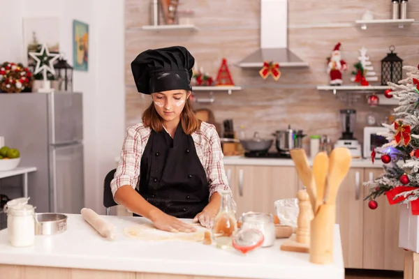 Barn bär bakning förkläde att sätta mjöl på hemlagad deg — Stockfoto