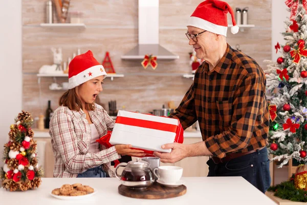 Enkelin überrascht Großvater mit Weihnachtsgeschenk — Stockfoto