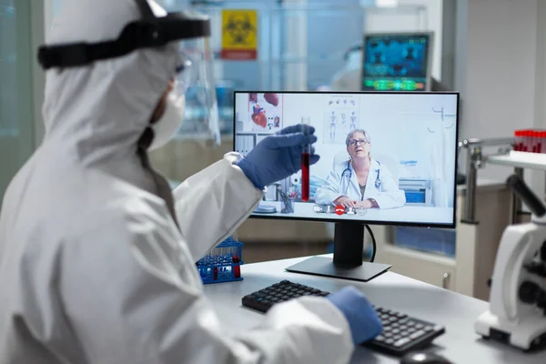 Biologist man holding medical test tube with infected blood discussing with researcher — Stock Photo, Image