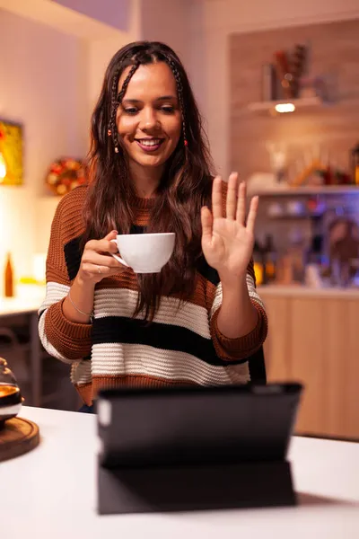Junge Erwachsene halten eine Tasse Tee in der Hand und winken im Online-Chat — Stockfoto