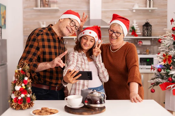 Família feliz tomando selfie usando smartphone fazendo expressões engraçadas — Fotografia de Stock