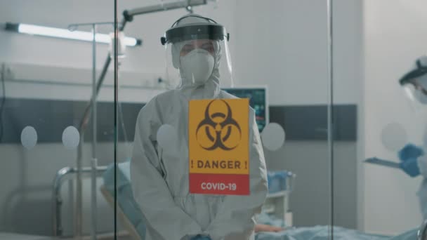 Retrato de la enfermera en traje de materiales peligrosos que permanece en la zona de cuarentena — Vídeos de Stock