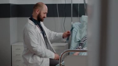 Doktor ve yaşlı hasta, sağlık için radyografiyi inceliyor.