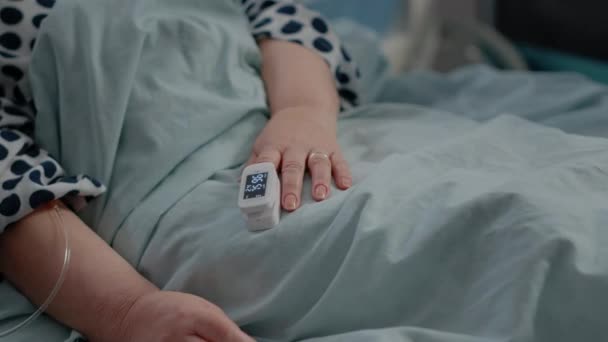 Close-up de oxímetro na mão do paciente sênior na cama — Vídeo de Stock