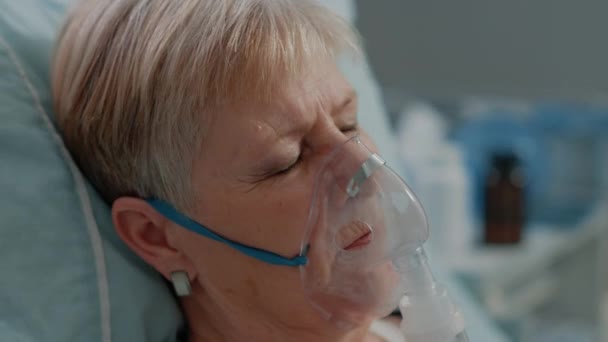Close-up van oudere patiënt met zuurstofmasker in bed — Stockvideo