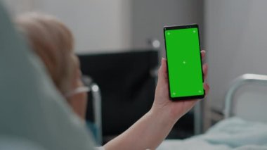 Dikey olarak yeşil ekran tutan yaşlı kadına yaklaş