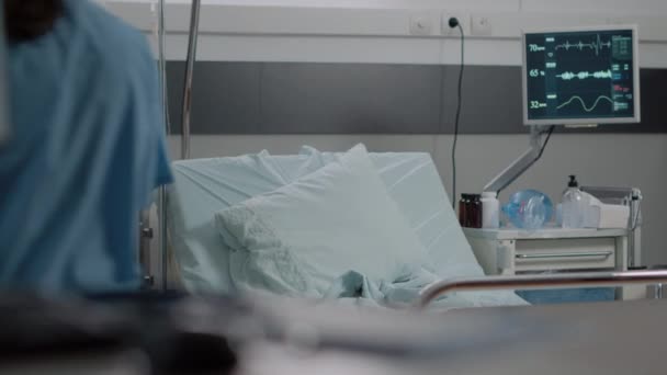 Nő, aki ápolóként dolgozik, ágyat készít elő a kórházi kórteremben. — Stock videók