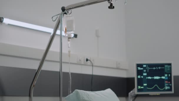 Κοντινό πλάνο της ενδοφλέβιας σακουλιάς και άδειο κρεβάτι νοσοκομείου — Αρχείο Βίντεο