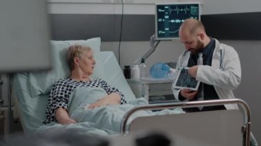 Sıhhiye tablet üzerindeki radyografi teşhisini hastaya açıklıyor