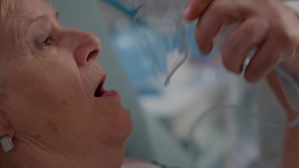 Крупным планом врач наносит кислородную маску на больного пациента — стоковое видео