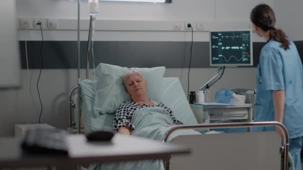 Пожилой пациент с болезнью, лежащий в палате больницы — стоковое видео