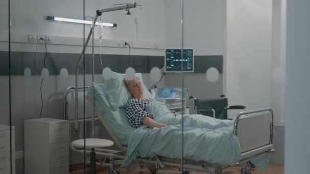 Женщина-медсестра проверяет спящего пациента в постели — стоковое видео
