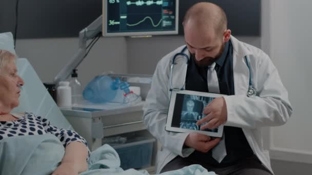 Paziente malato guardando la scansione a raggi X su tablet per i risultati degli esami — Video Stock