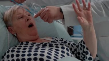 Doktor hiperventilasyon geçiren hastanın yüzüne oksijen maskesi takıyor.
