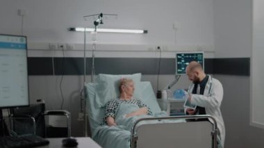 Doktor, sağlık muayenesi için röntgen taramasıyla tableti tutuyor.