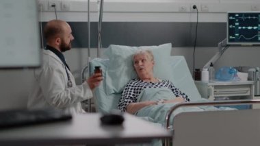 Doktor elinde ilaç şişesi tutuyor ve tedaviyi açıklıyor.