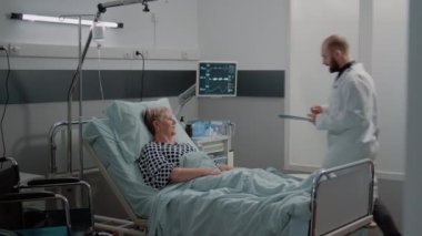 Doktor ve hemşire hasta kadın için oksimetreye bakıyorlar.