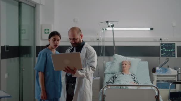 Lekarz z laptopem omawianie z pielęgniarką przed konsultacją — Wideo stockowe