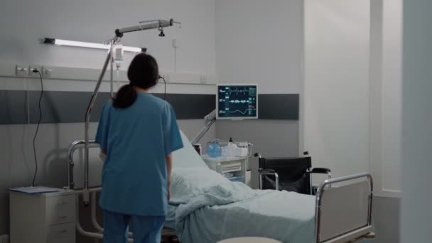 Medische assistent bereidt ziekenhuisafdeling bed voor patiënt — Stockvideo