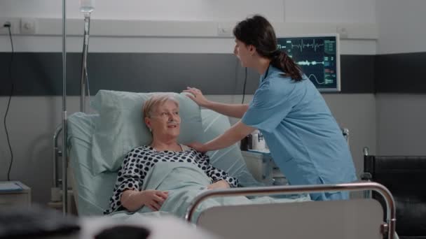 Doctor doing consultation with senior patient in hospital ward — Stock Video