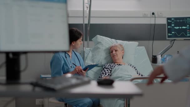 Equipe médica consultar paciente doente com oxímetro deitado na cama — Vídeo de Stock