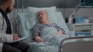Hastalıklı kıdemli hasta doktorla tedaviyi tartışıyor