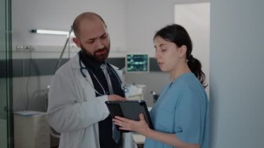 Doktor ve hemşire hasta tedavisi hakkında konuşuyorlar.