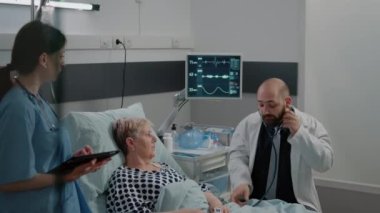 Doktor kalp atışı ölçümü için steteskop kullanıyor.