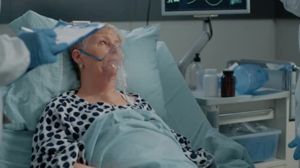 Alderen kvinde med coronavirus symptomer iført ilt maske – Stock-video