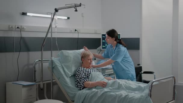 Врач и медсестра проводят консультации для больного пациента в постели — стоковое видео