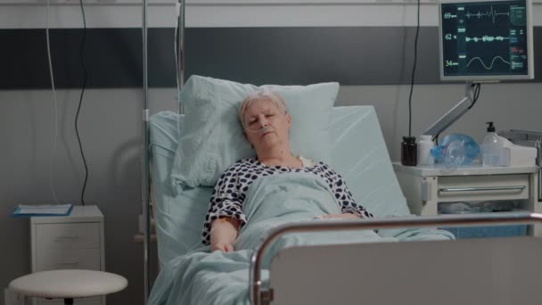 Oudere vrouw met infuuszak slapen in ziekenhuisafdeling bed — Stockvideo