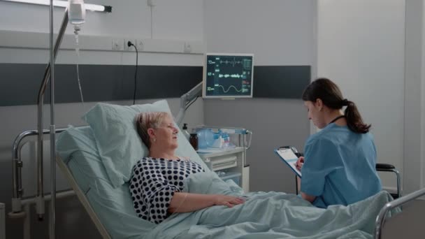 Medische assistent in overleg met gepensioneerde patiënt — Stockvideo