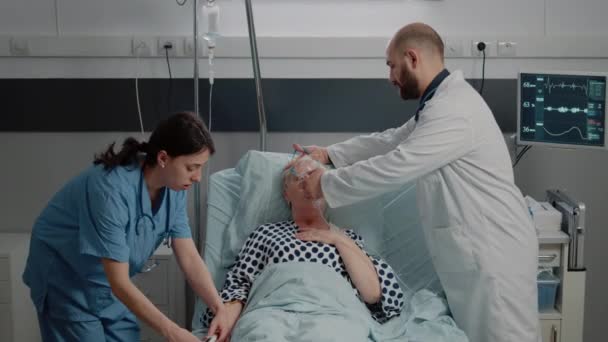 Doctor and nurse helping ill woman breathing heavily — Stock Video