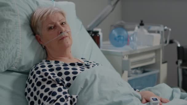 Porträt einer kranken Seniorin, die in die Kamera blickt — Stockvideo