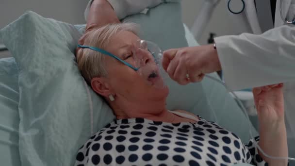 Sjuk patient andas tungt medan läkare ger hjälp — Stockvideo