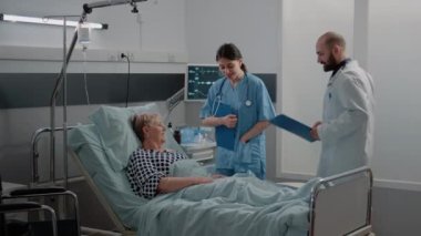 Hastalıklı yaşlı bir hasta için sağlık ekibi sağlık kontrolü yapıyor.
